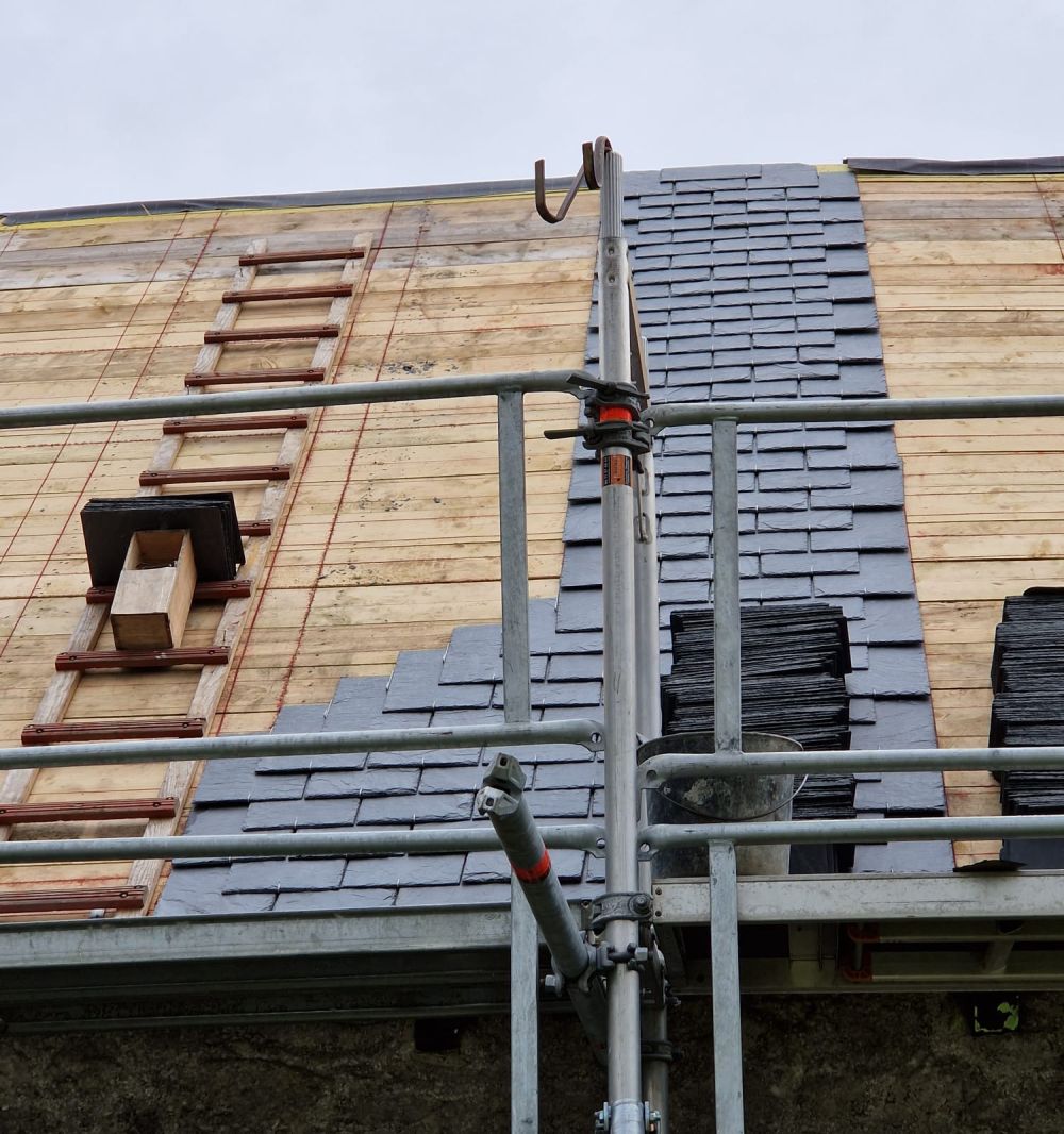 Couvreur posant une couverture en ardoises, près de Lannion en Bretagne